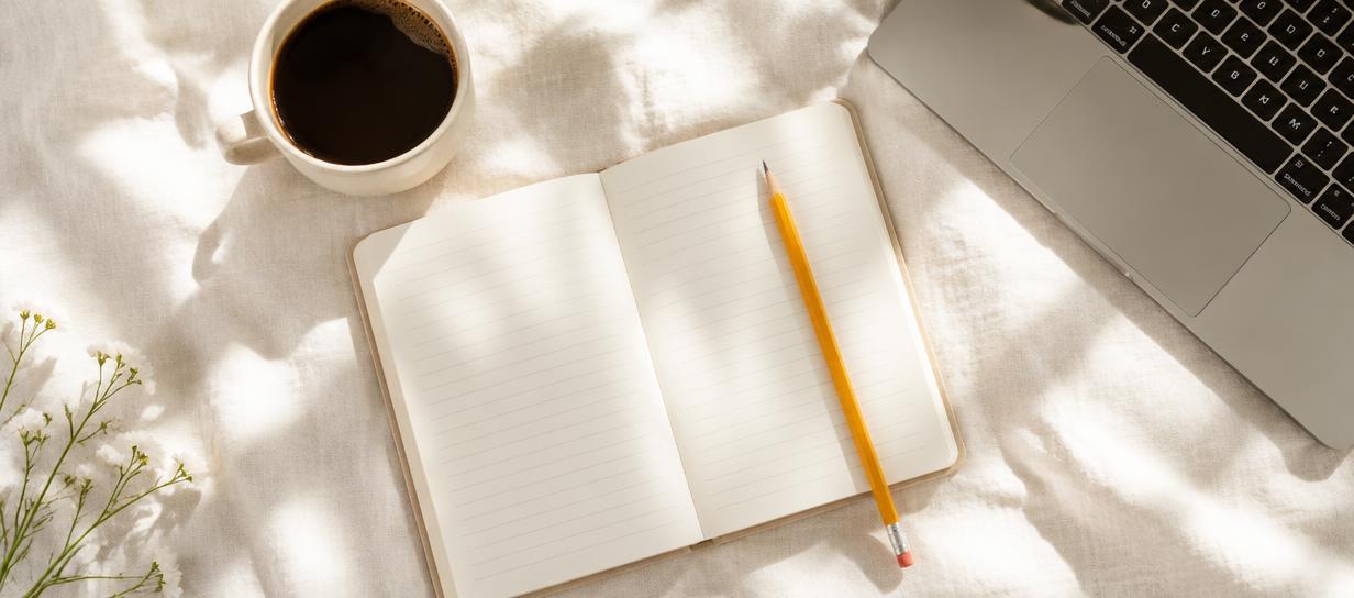 Buku nota, pensel kuning dan laptop di atas kain linen